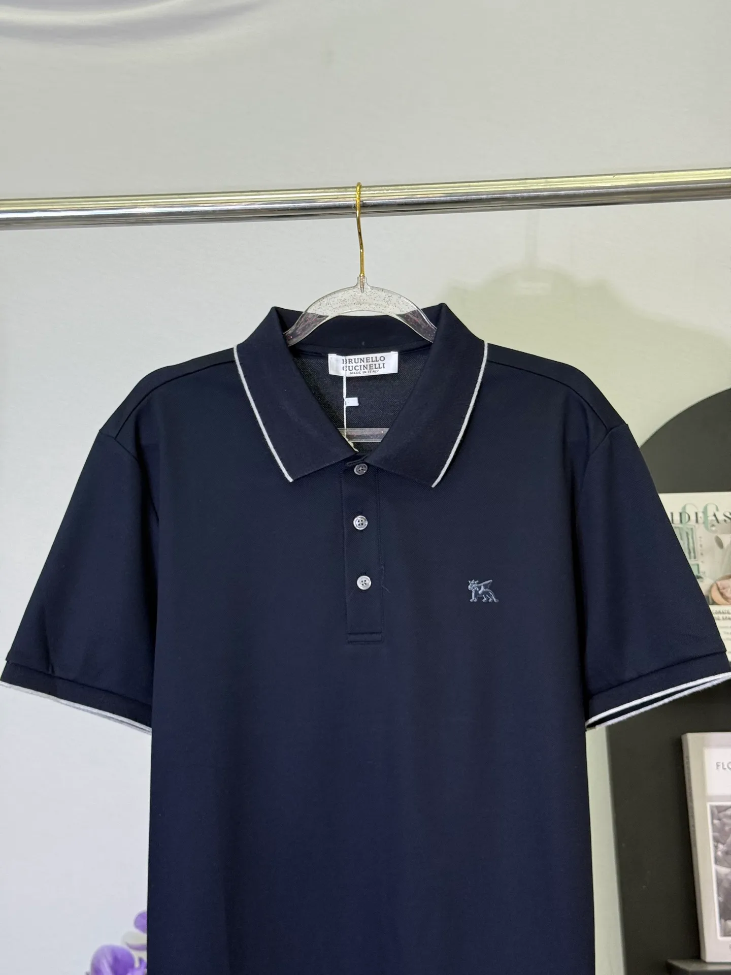 💋 Brunello Cucinelli Navy Pegasus Polo Shirt. Put the low-key luxury of Italy’s “King of Cashmere” into this calm navy blue Polo. The delicate Pegasus embroidery on the chest, with contrasting white edge details on the collar and cuffs, is low-key yet highly recognizable on the deep navy blue background. It is the first choice for players who truly understand texture. The high-count piqué cotton fabric is selected to be drape-resistant and wrinkle-resistant. The upper body has a neat and straight noble feeling. The fit is slightly loose and does not matter the body shape. It can be easily held in business commuting and light formal occasions. A navy blue Polo can guarantee your dignity and style in all occasions in four seasons. M-3XL